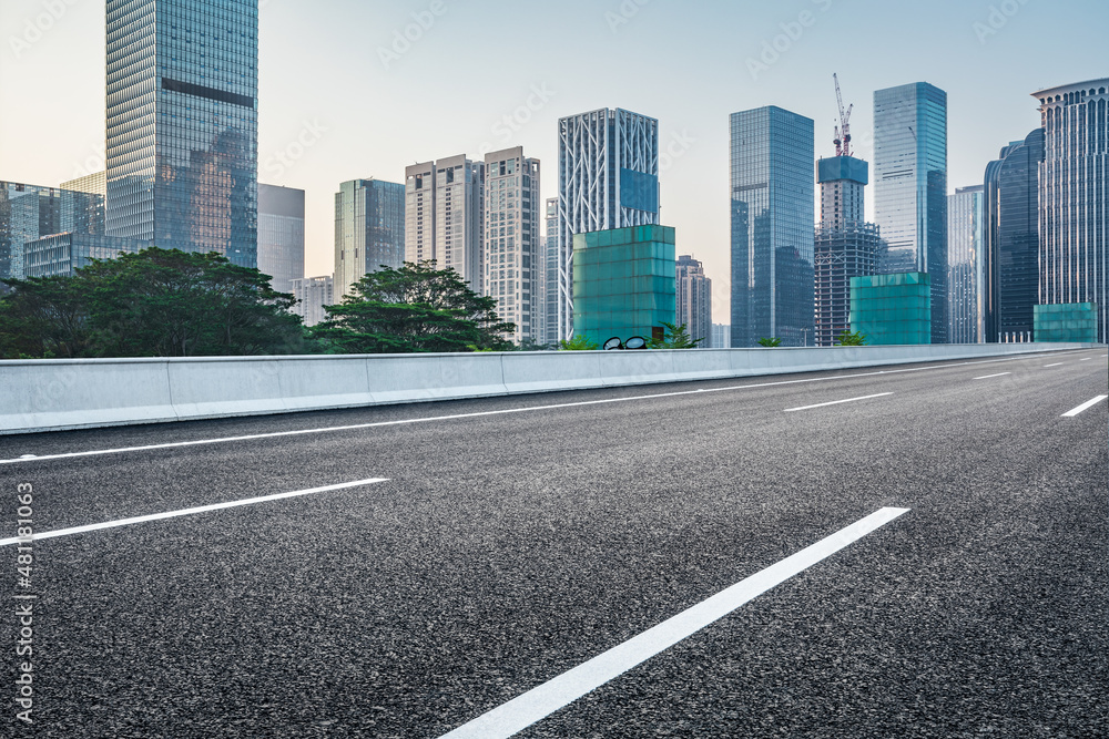 中国深圳的沥青道路和城市天际线，以及现代化的商业办公楼。