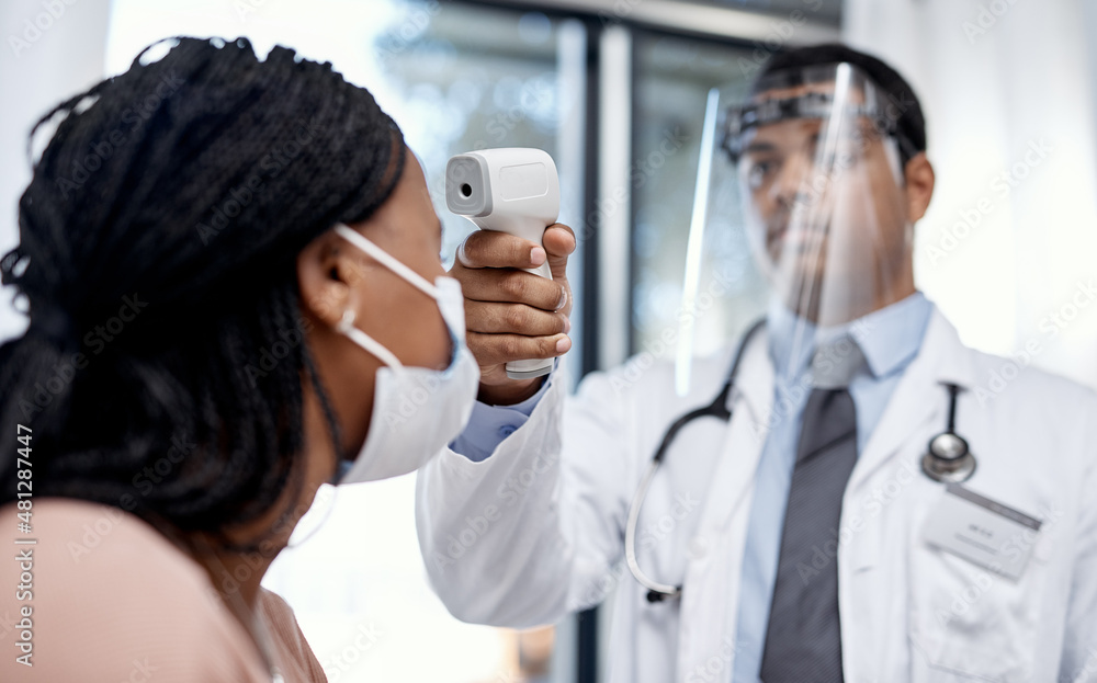 Getting screened for everyones safety. Shot of a doctor taking a patients temperature with an infr