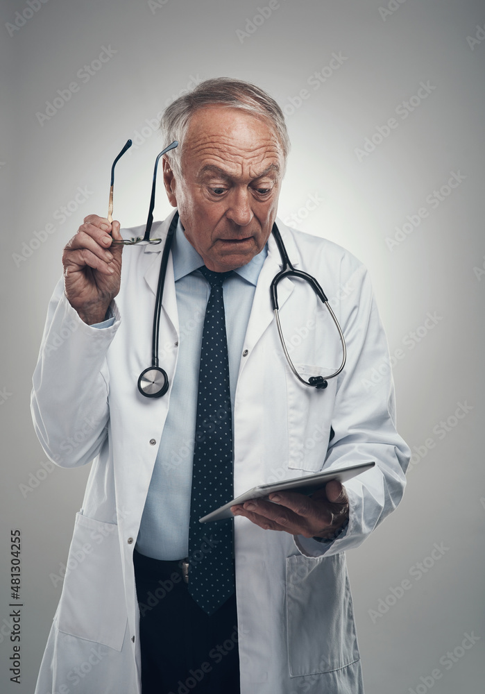 These are some shocking results. Shot of an elderly male doctor using a digital tablet in a studio a