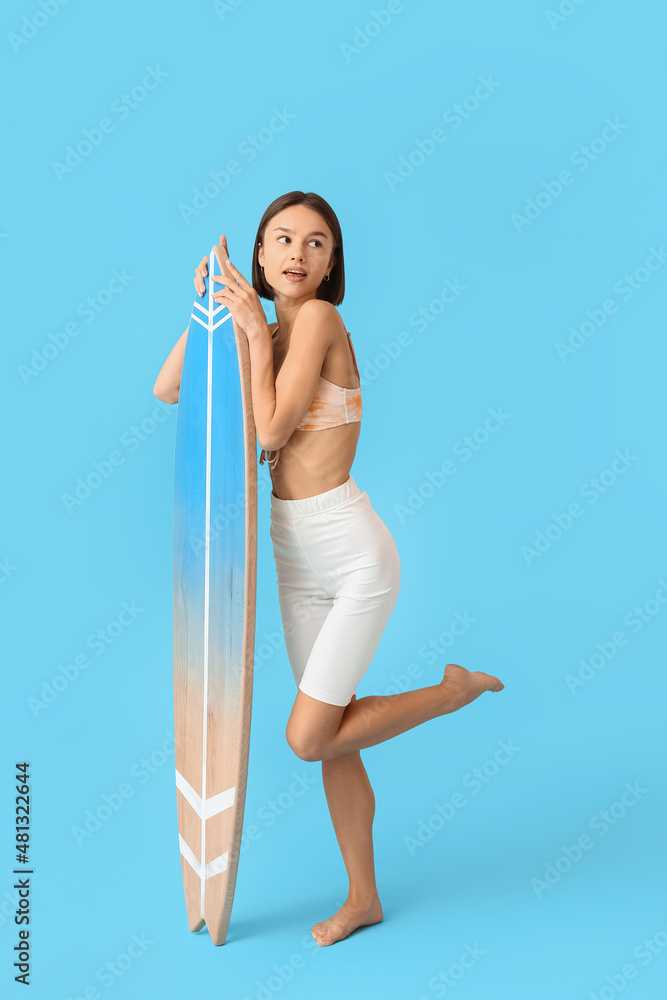 Beautiful young woman with surfboard on color background