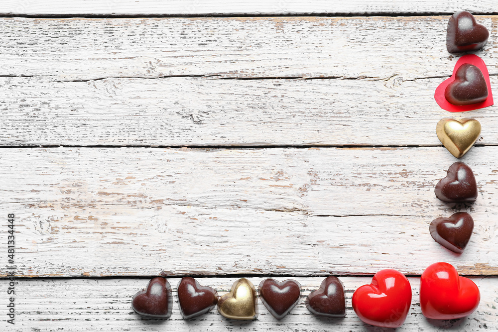 Tasty heart-shaped candies on light wooden background