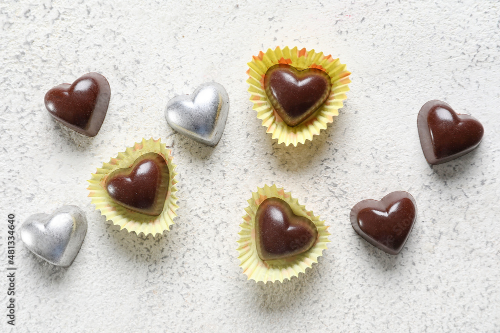 Tasty heart-shaped candies on light background