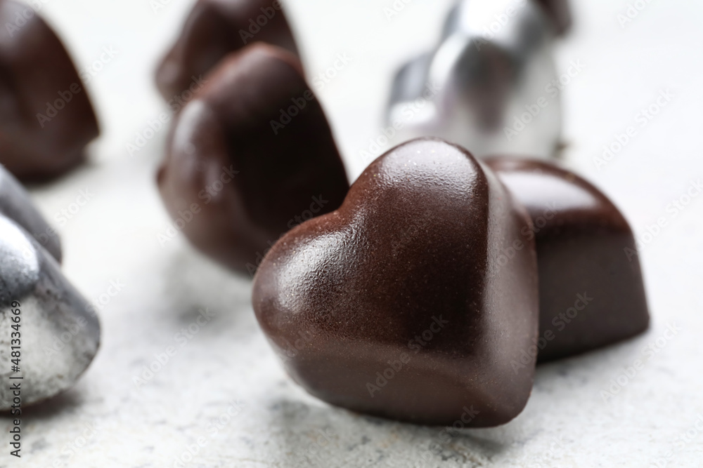 Tasty heart-shaped candies on light background, closeup