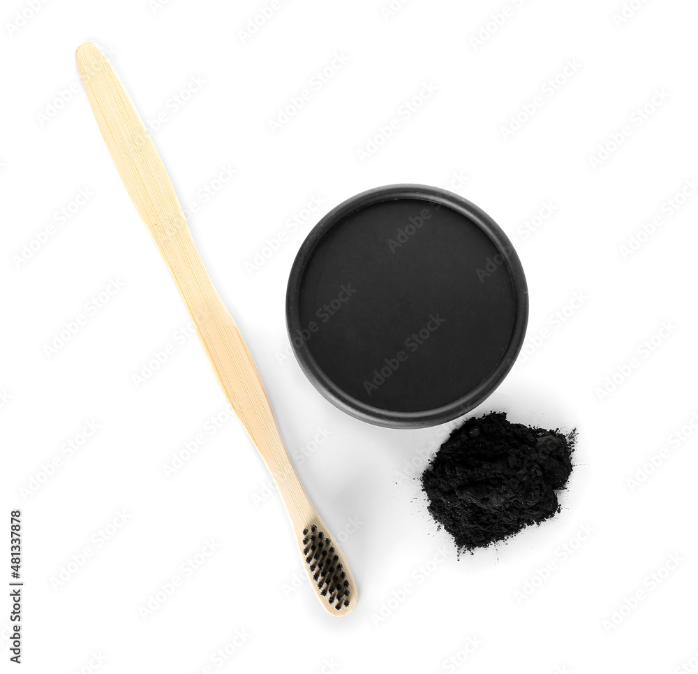 Activated charcoal tooth powder and toothbrush on white background