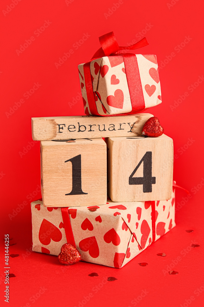 Calendar with date of Valentines Day and gift boxes on red background