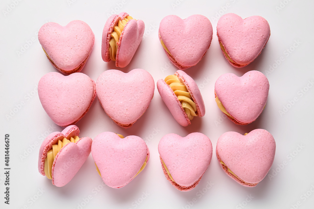 Tasty heart-shaped macaroons on white background