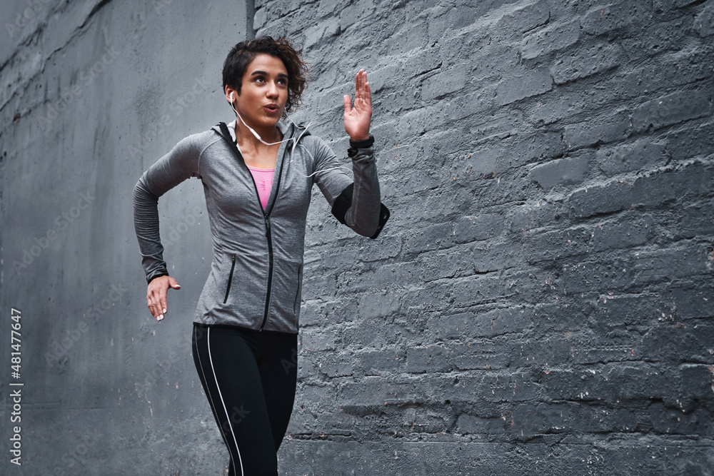 I choose to be fit. Cropped shot of an attractive young woman wearing earphones and workout clothes 