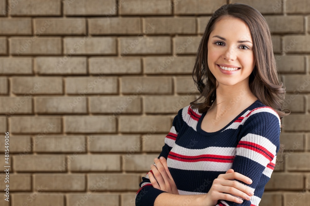 Attractive beautiful positive woman, over the brick wall. Portrait