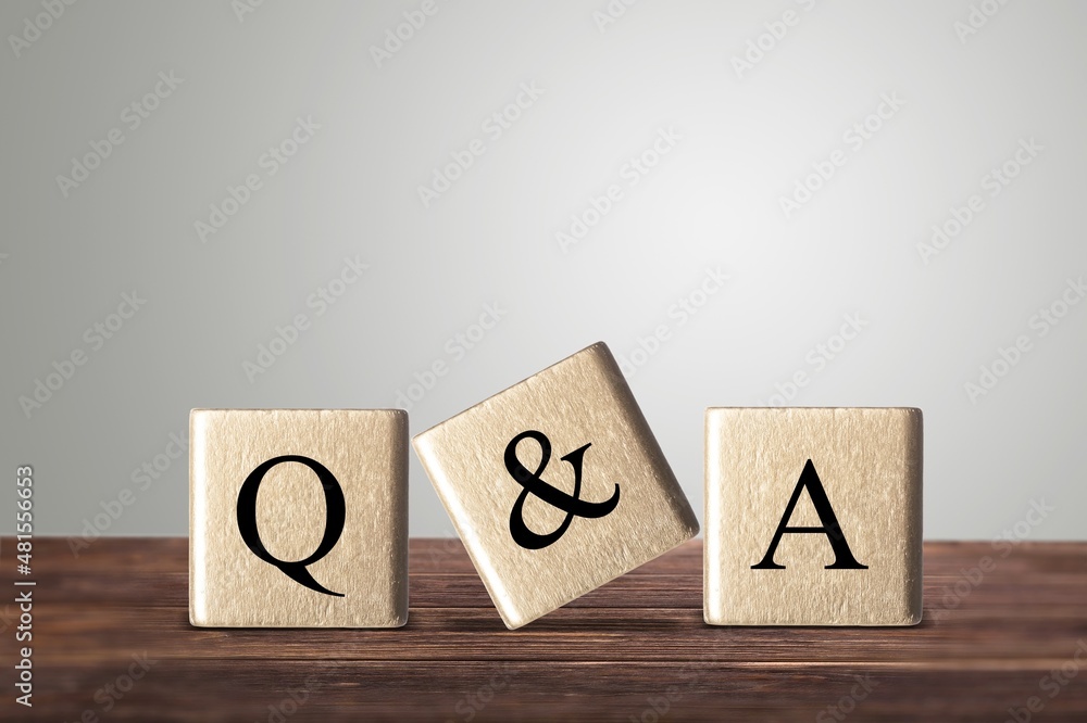 Three wooden cubes with the letters Q and A on the table.