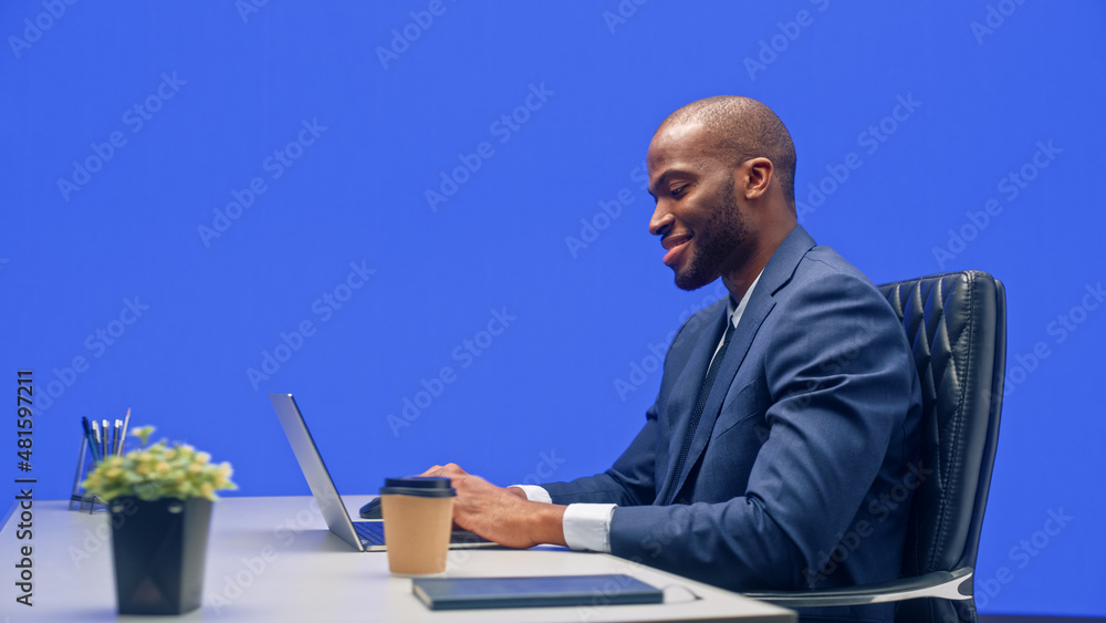 Green Screen Office Background: Black Businessman Sitting at His Desk Working on a Laptop Computer. 