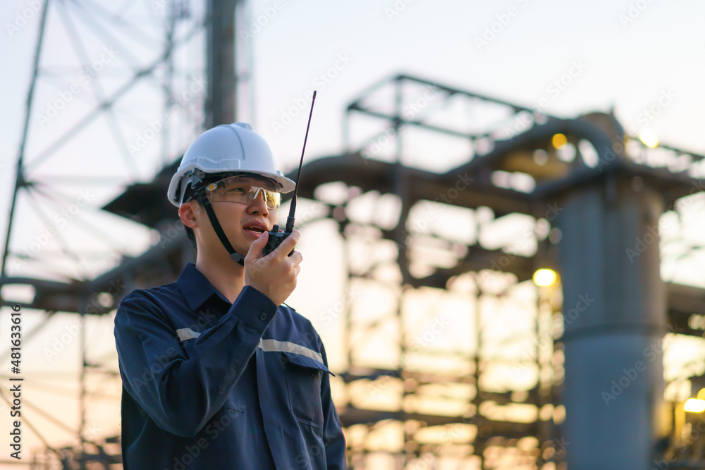 Asian man technician Industrial engineer using walkie-talkie in oil refinery for building site surve