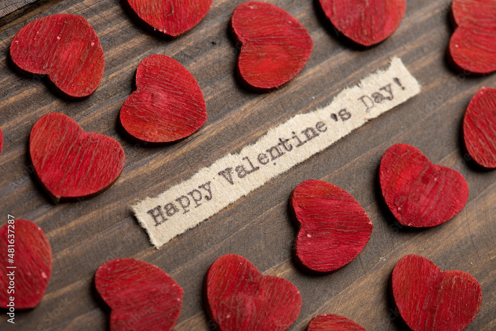 Happy Valentine`s day - typed text. Valentines Day greetings concept. Little red wooden hearts close