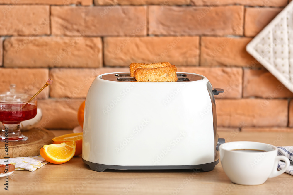 White toaster with tasty breakfast on counter near brick wall