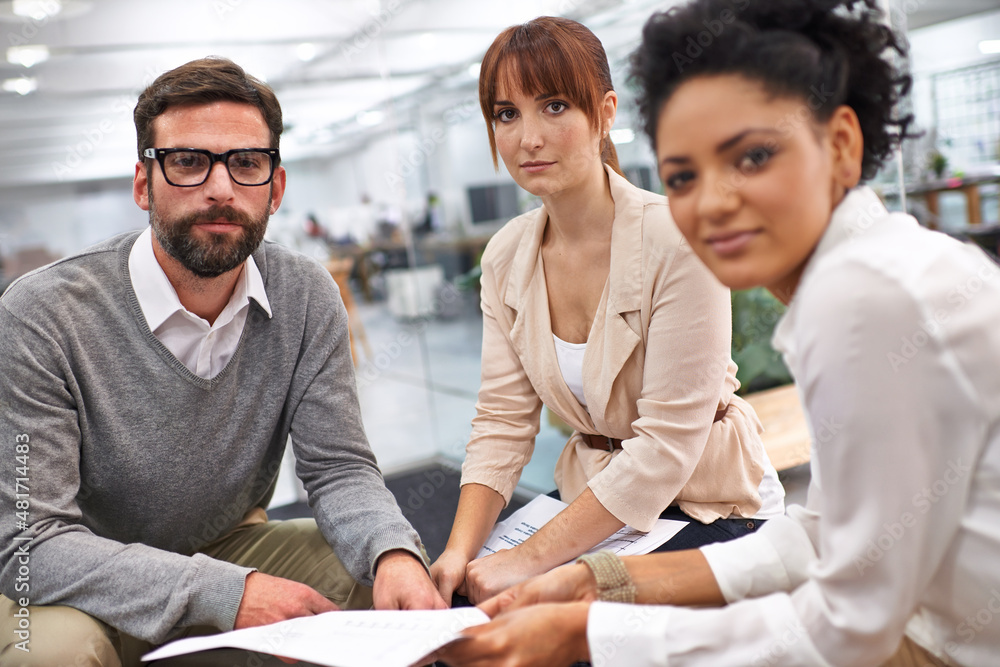 Running through the contracts details. Shot of a group of young professionals discussing paperwork.