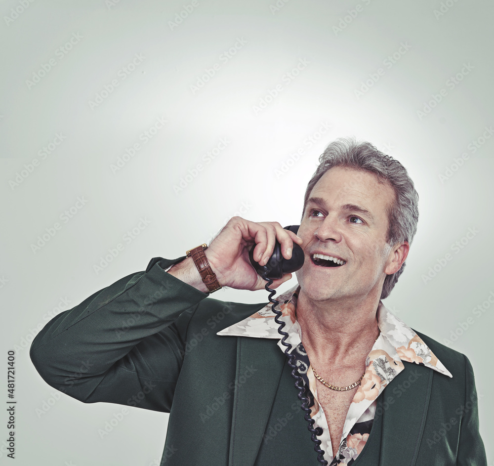 He knows people in important places. Cropped studio shot of a mature man in a retro suit talking on 