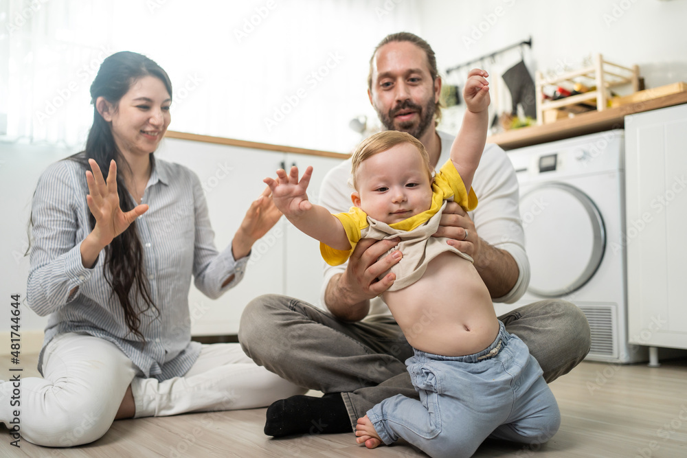 高加索男婴在家里在父母的支持下学会走路。