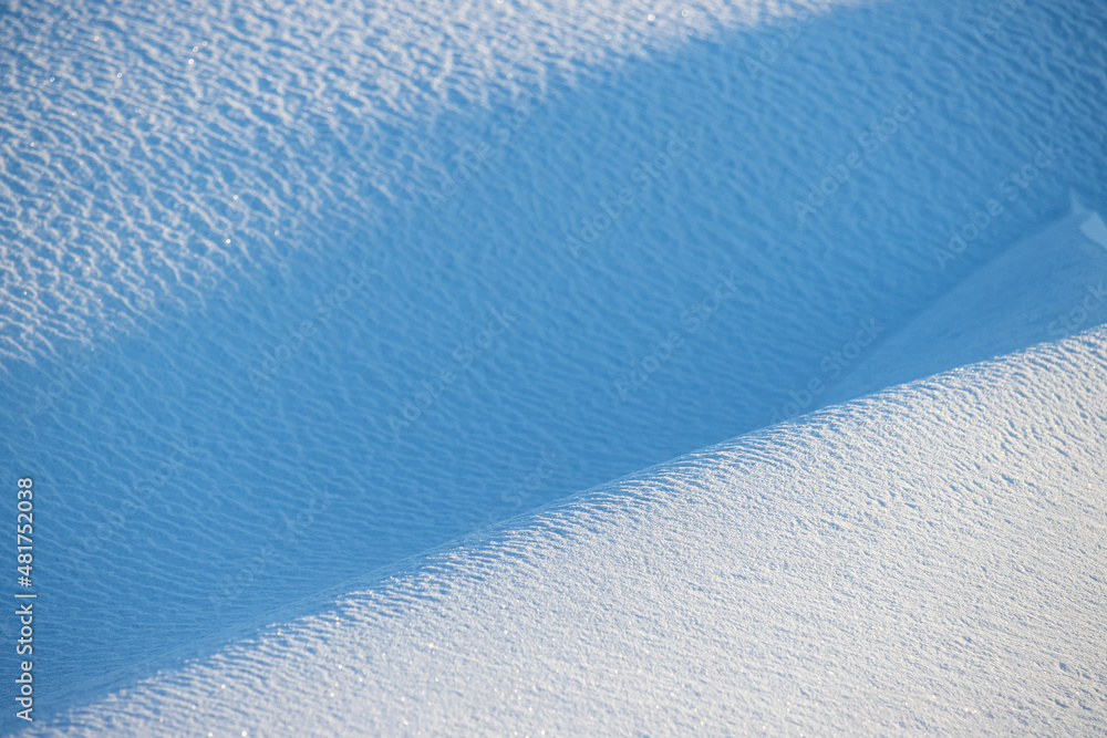 美丽的冬季背景，雪地。自然的雪纹理。风在雪上雕刻的图案