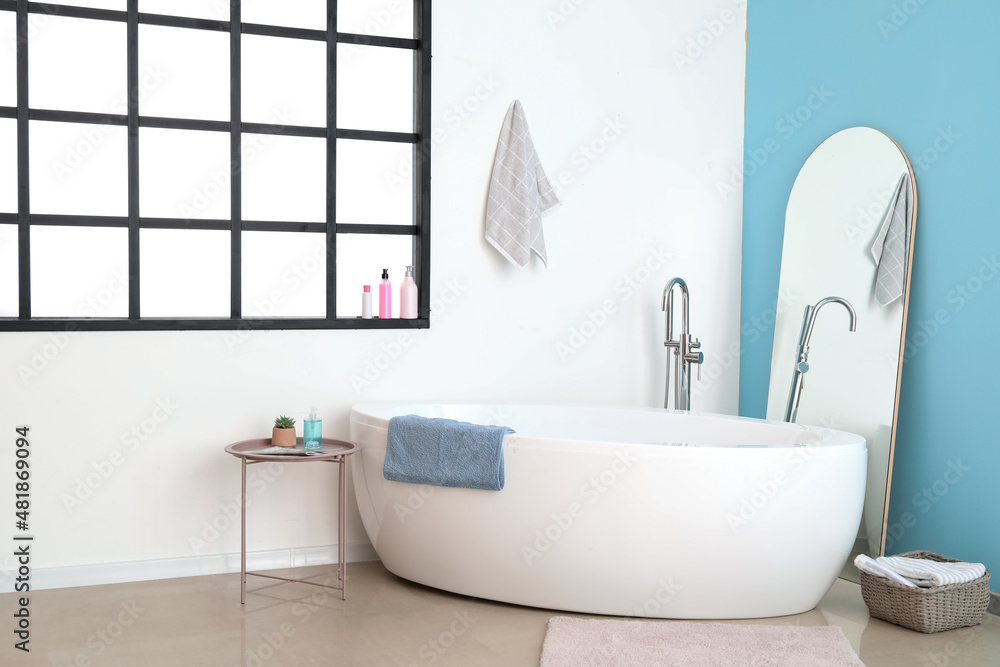 Modern bathtub in interior of modern bathroom