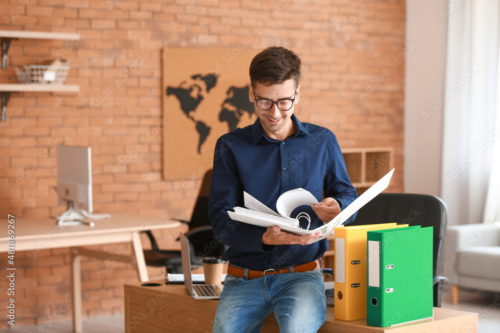 Young man with open folder in office