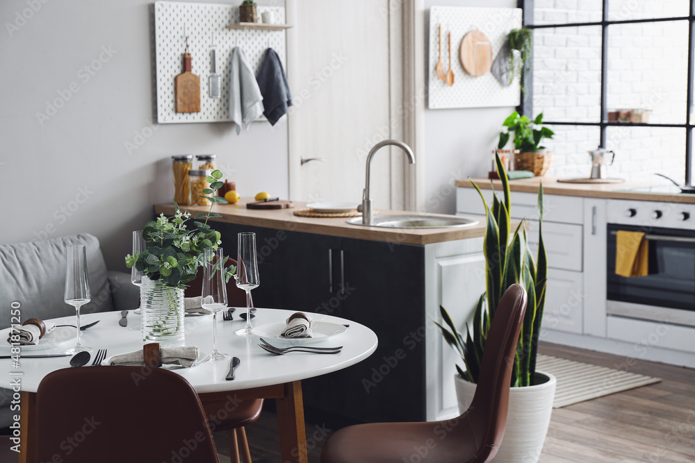 Interior of modern kitchen with counters, dining table and peg boards