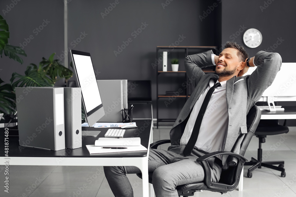 Smiling young businessman relaxing in office