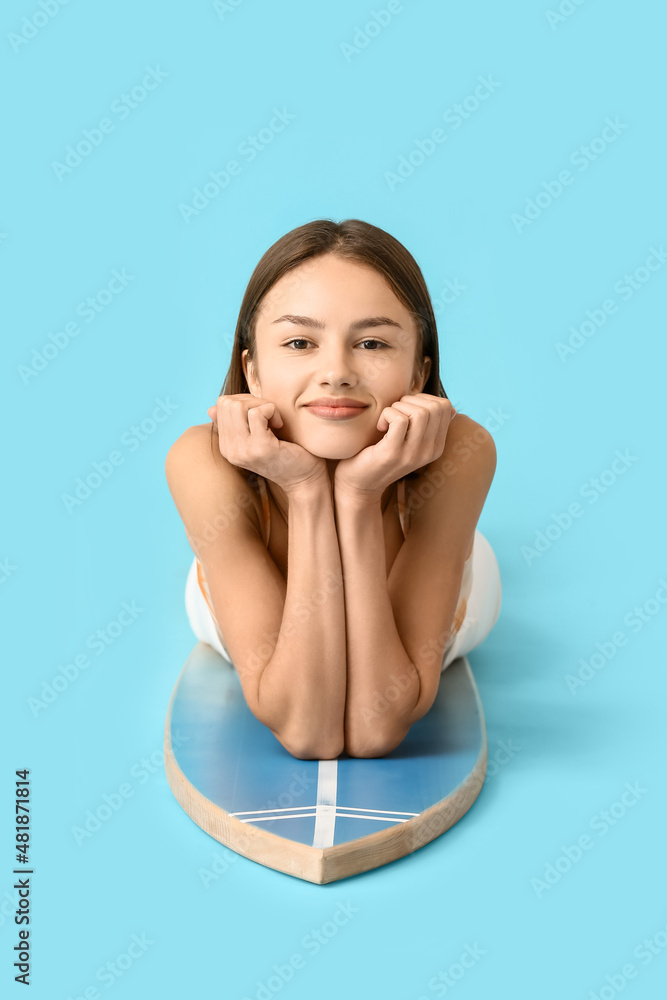 Beautiful young woman with surfboard on color background