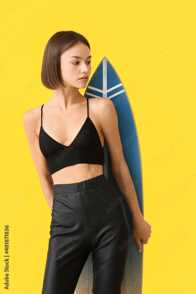 Beautiful young woman with surfboard on color background