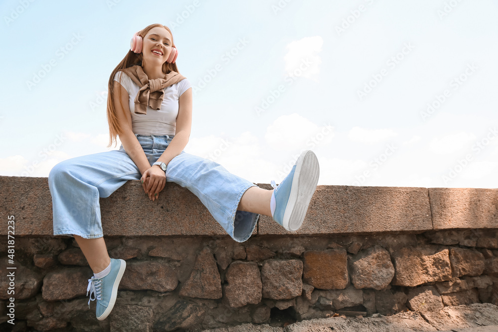 酷酷的年轻女人在户外听音乐