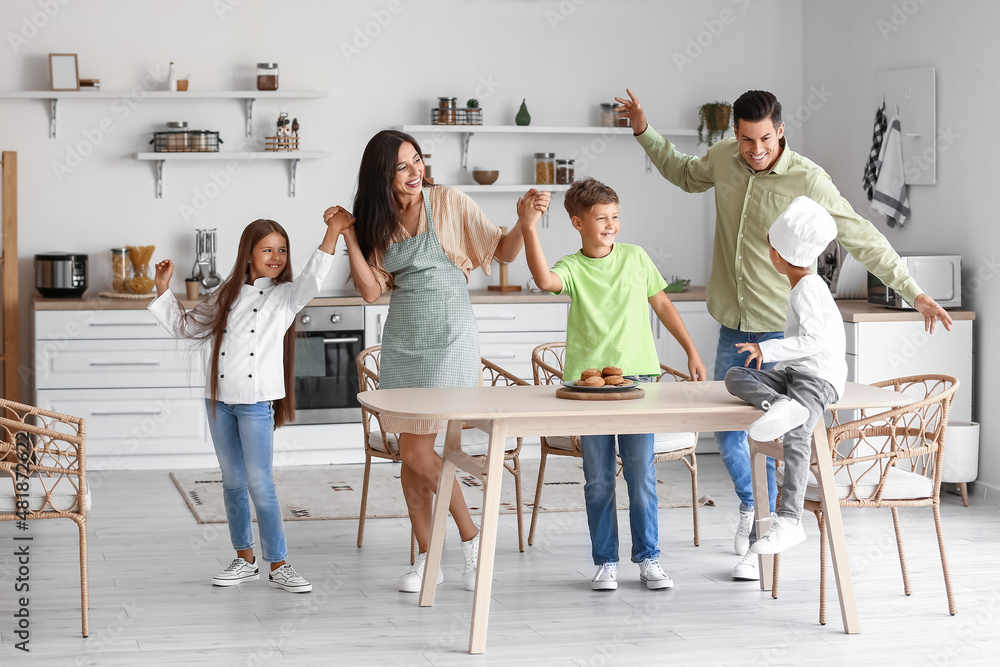 Happy  family dancing in kitchen