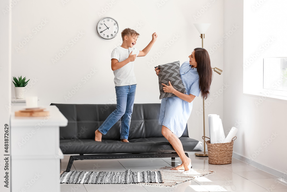 Happy mother and son dancing at home