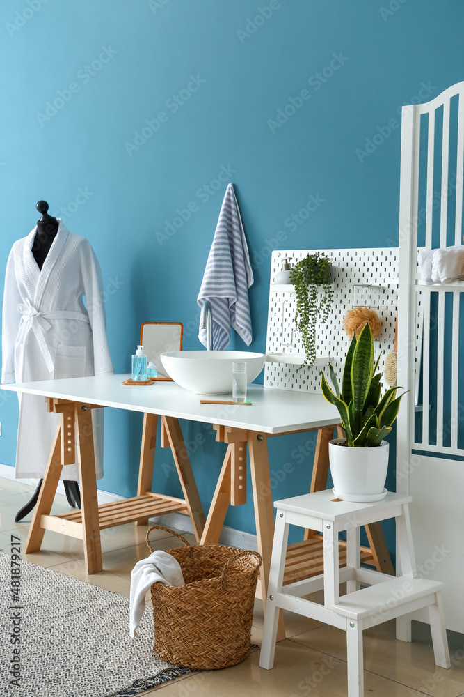 Interior of stylish bathroom with sink, pegboard and mannequin