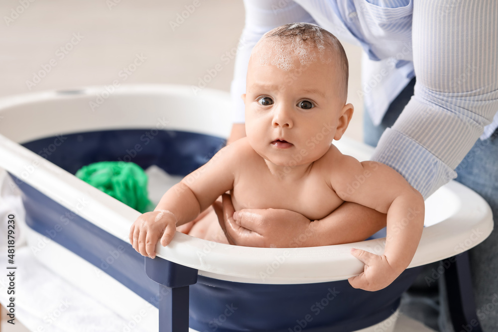 Mother washing her baby boy with at home