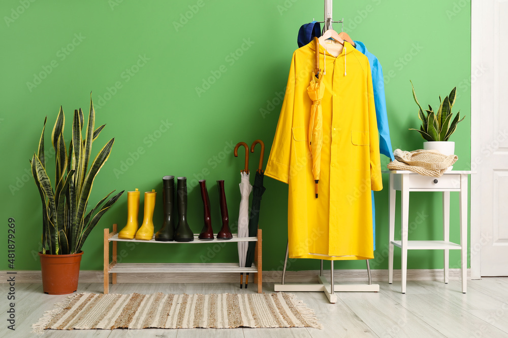 Interior of stylish hall with raincoats and gumboots