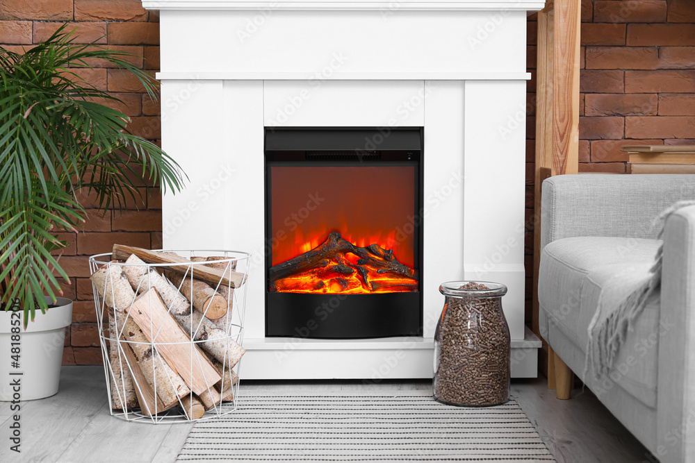 Basket and jar with firewood near fireplace in modern living room