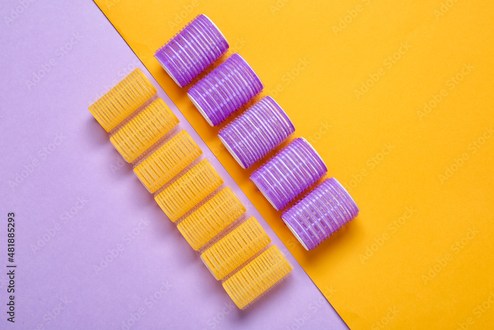 Set of different hair curlers on color background