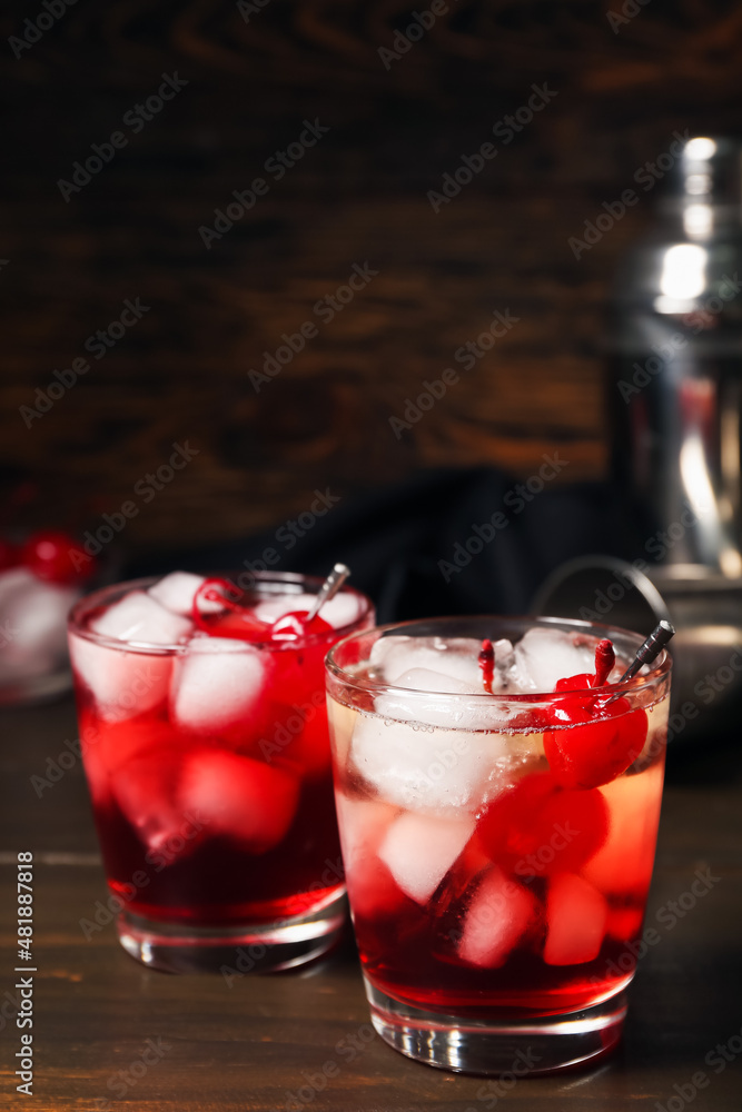 Glasses of tasty Manhattan cocktail on dark wooden background