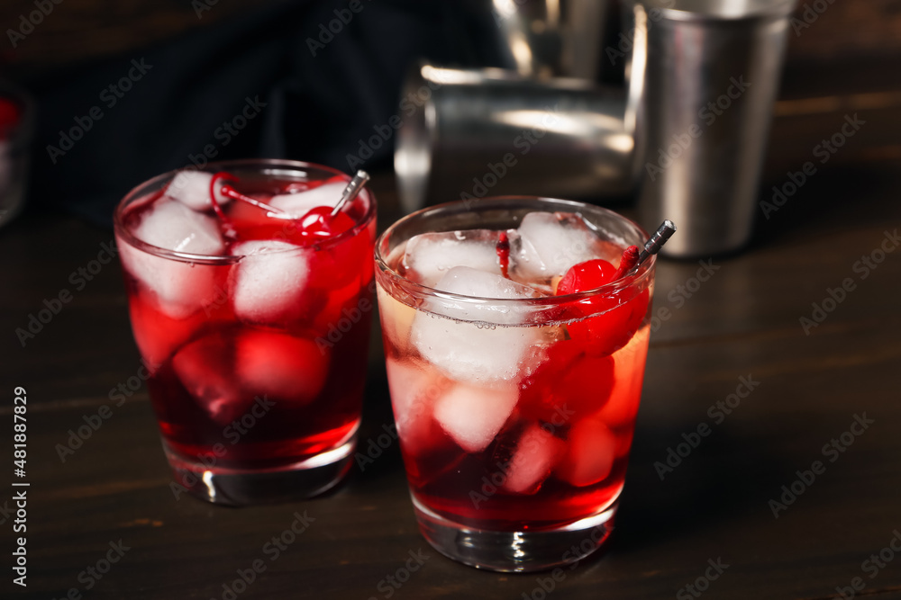 Glasses of tasty Manhattan cocktail on dark wooden background