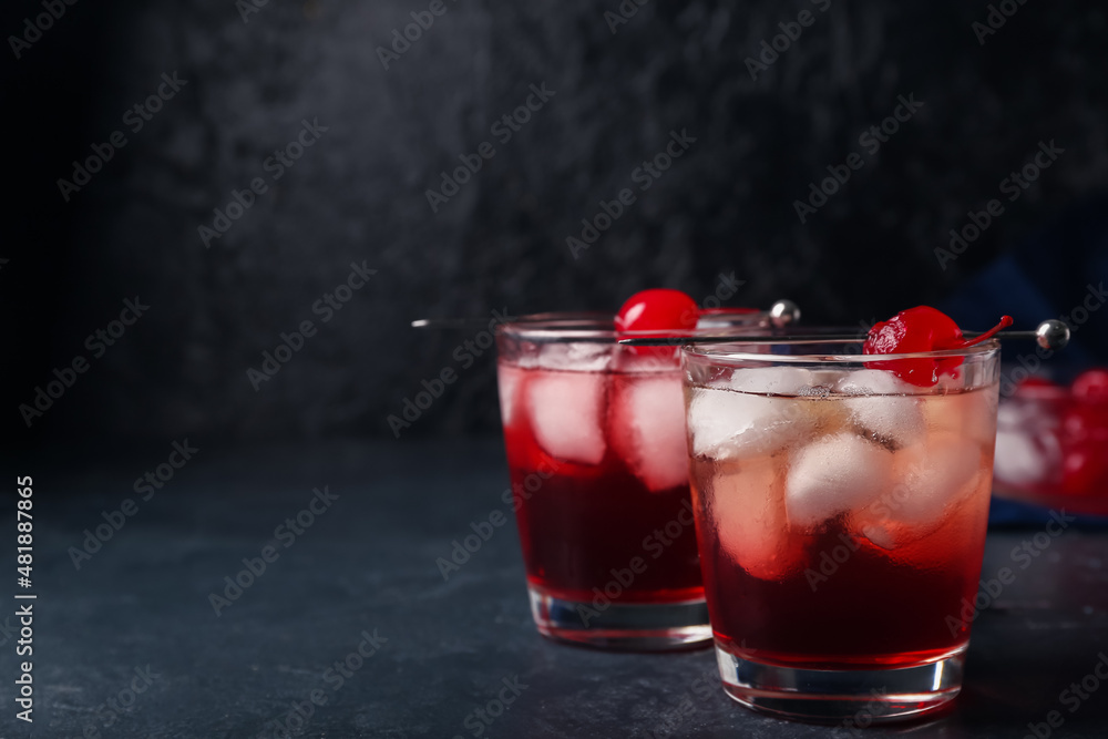 Glasses of tasty Manhattan cocktail on black background