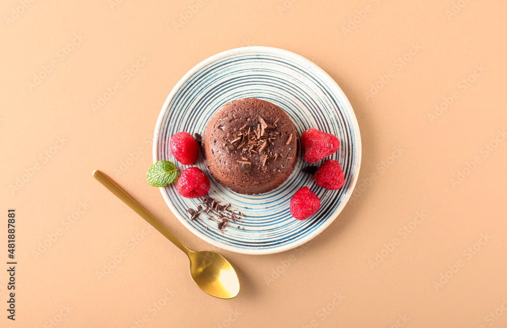 Plate with tasty lava cake fondant and raspberry on color background