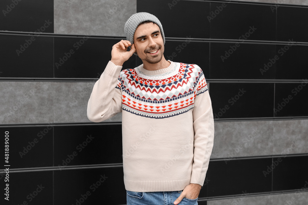 Handsome young man in knitted sweater outdoors