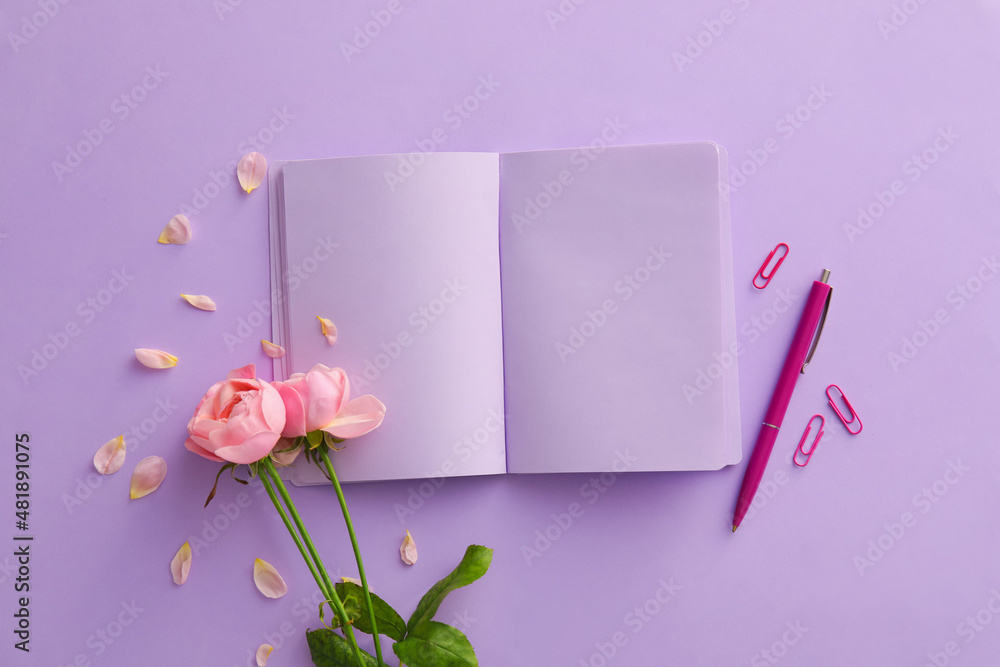 Composition with blank open notebook, pen and rose flowers on lilac background