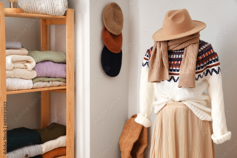 Mannequin with accessories, warm sweater and skirt in dressing room