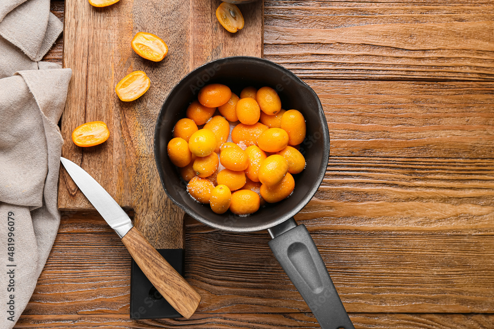 Preparing of tasty kumquat jam on table