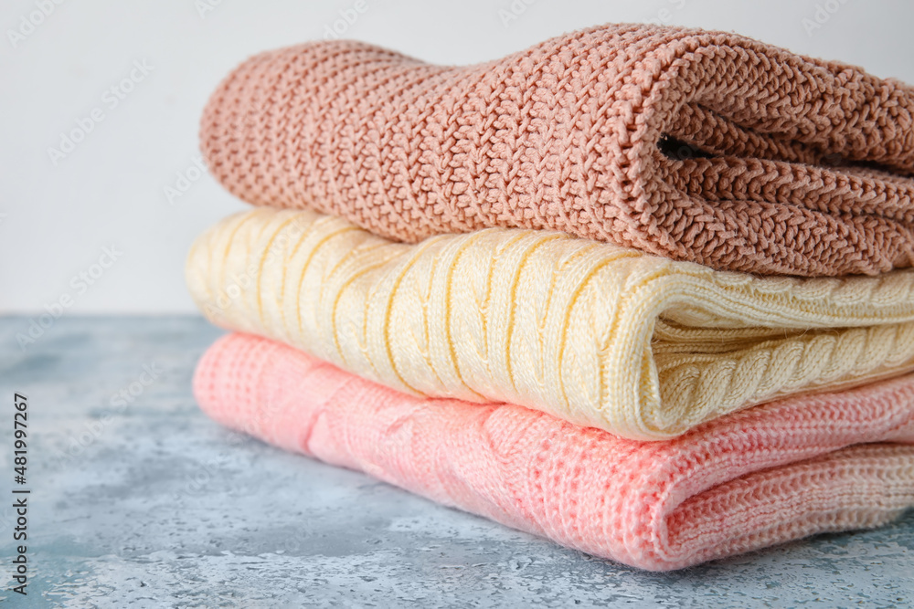 Stylish baby sweaters on table, closeup