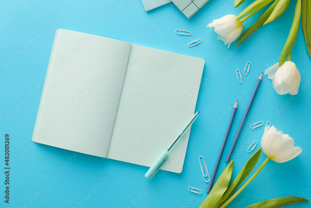 Composition with blank notebook, stationery and beautiful tulips on color background