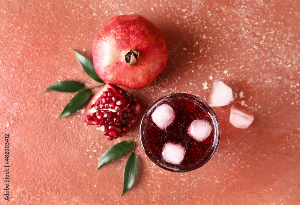 Glass of iced pomegranate juice on red background