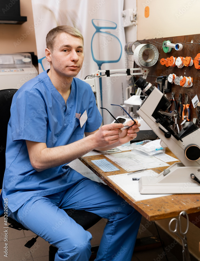 Handsome young ophthalmologist making eyeglasses.