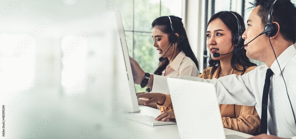 Business team wearing headset working actively in office . Call center, telemarketing, customer supp