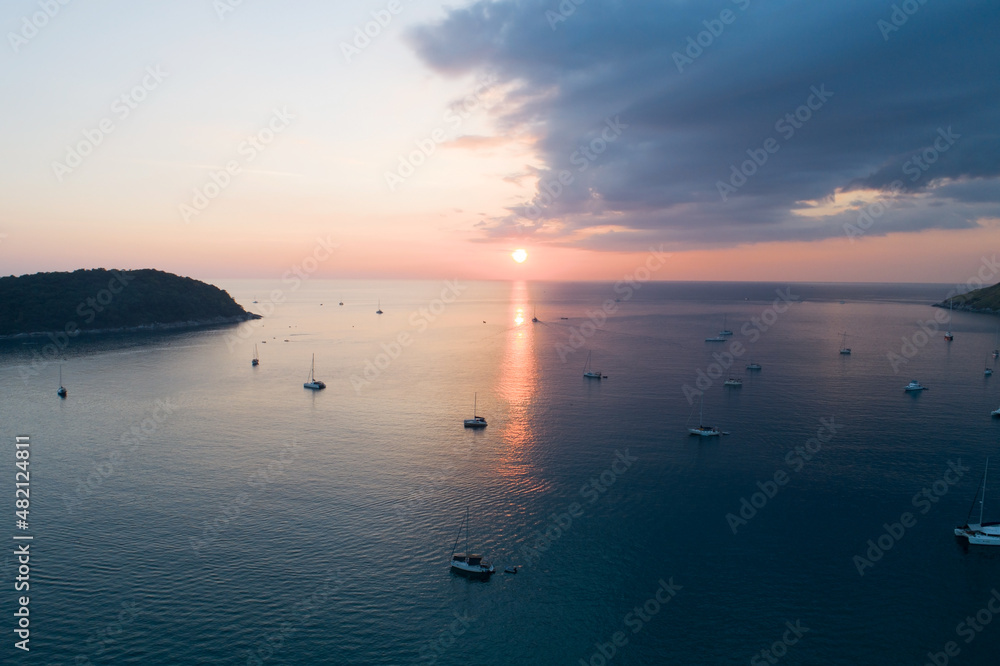 Colorful sunset above the sea surface with sail boats Aerial view drone fly over Phuket sea Reflecte