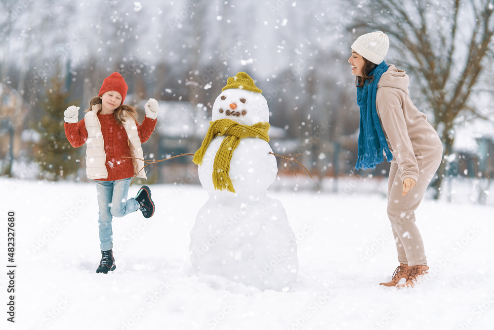 Mother and child girl on a winter walk